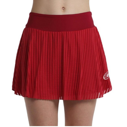 Front view of female model wearing red pleated Bullpadel Exito women's skort