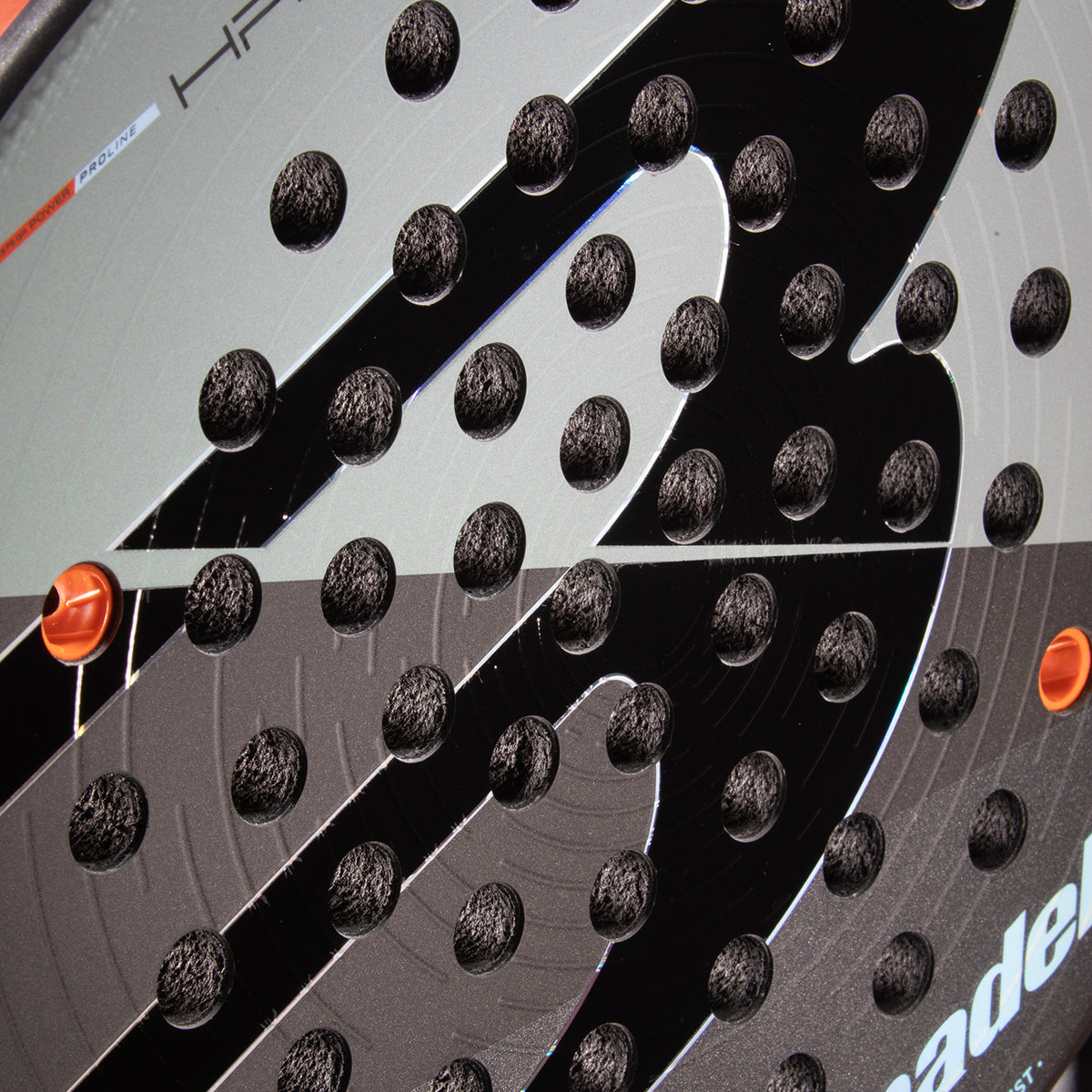 Close-up detail of textured face pattern and hole drill layout on Bullpadel Hack 04 Comfort 26 racket