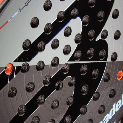 Close-up detail of textured face pattern and hole drill layout on Bullpadel Hack 04 Comfort 26 racket